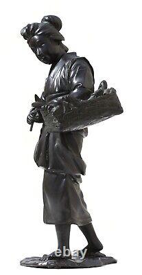 Un modèle en bronze d'une demoiselle héron tenant un panier à poissons japonais, période Meiji